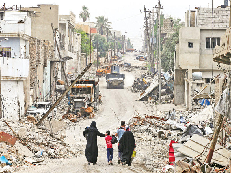 أسرة عراقية تغادر موطنها في أيمن الموصل أمس (رويترز)