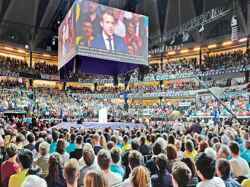  أنصار ماكرون يستمعون لخطابه في اجتماع عام بقصر الرياضة في ليون في 4 فبراير   (أ ف ب)