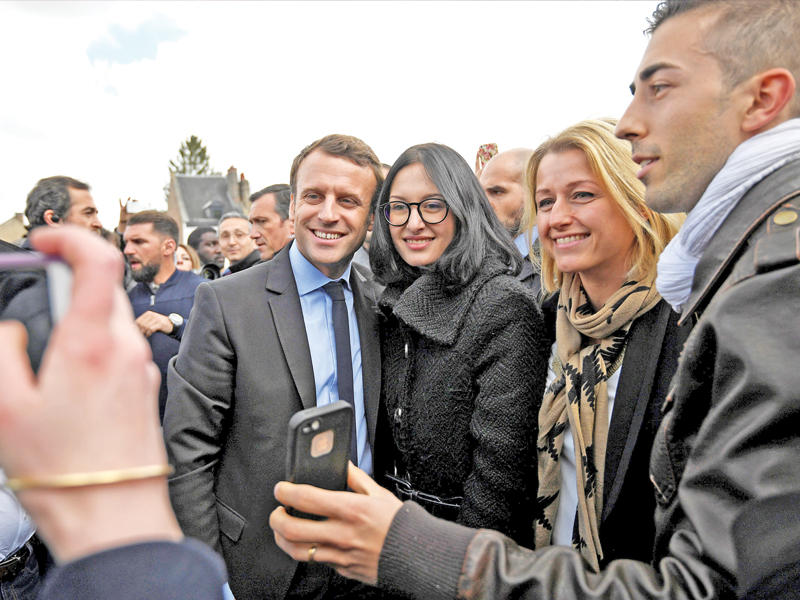 ماكرون وسط أنصاره خارج كاتدرائية في أميان شمال شرق فرنسا اليوم (رويترز)