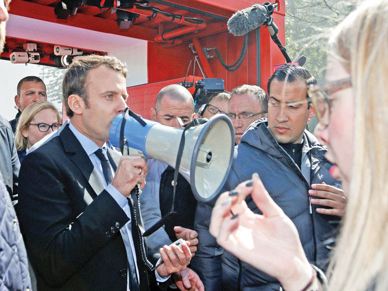 ماكرون يخاطب عمال مصنع أميان بمكبر صوت أمس tt(رويترز)