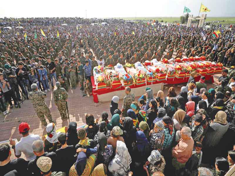 مقاتلات من الوحدات الكردية يتقدمن مراسم تشييع قتلى الغارات التركية في مدينة دريك أمس الأول (رويترز) 