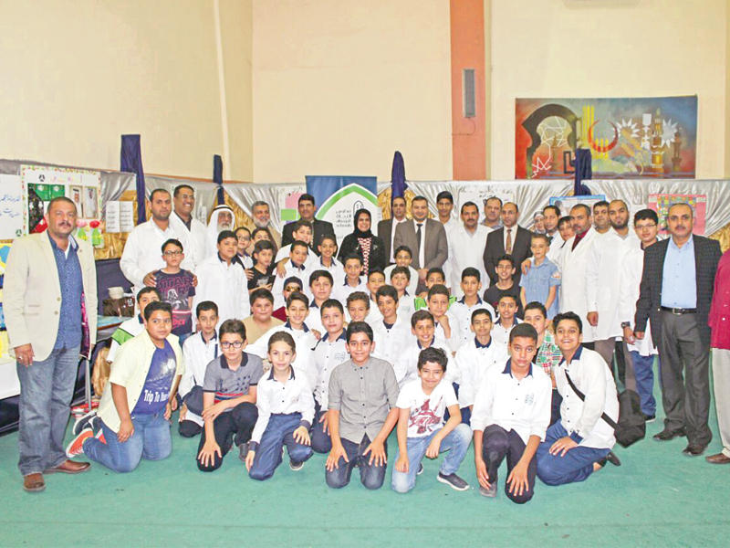 لقطة جماعية  للمعلمين والطلبة المشاركين في المعرض مع إدارة المدرسة