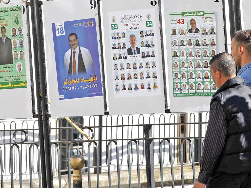 جزائريان يمران أمام لافتات اتخابية (أرشيف)