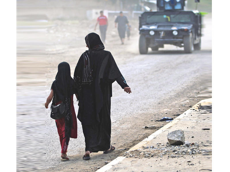عراقية وابنتها في حي باب الأبيض بالموصل  اليوم     (أ ف ب)