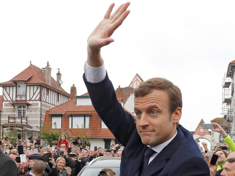 ماكرون بعد إدلائه بصوته في لاتوكيه أمس (رويترز)