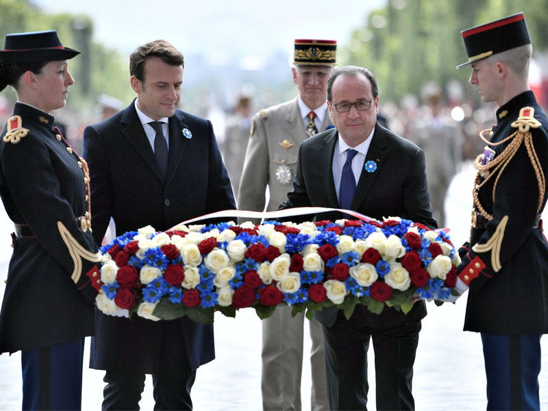 ماكرون وهولاند خلال احتفال بذكرى الانتصار على النازيين أمس في باريس (رويترز)
