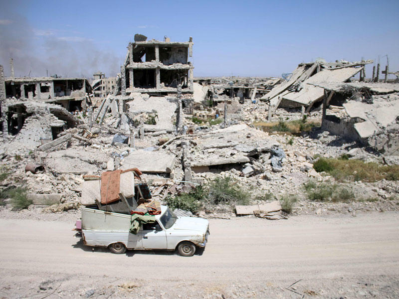 سيارة متهالكة تحمل أغراض عائلة سورية نازحة في درعا الجنوبية أمس الأول     (أ ف ب)