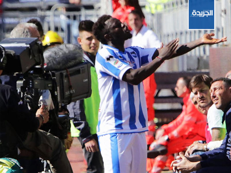 اللاعب الغاني سولي مونتاري يرد على هتافات الجمهور العنصرية بالإشارة إلى بشرته.