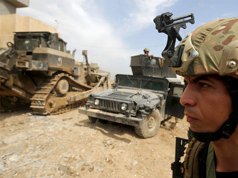 أفراد من خدمات مكافحة الإرهاب العراقية في الشارع وهم يتقدمون نحو حي الإصلاح الزراعي، غرب الموصل