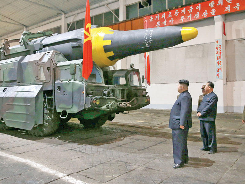 كيم جونغ أون أمام صاروخ «هواسونغ 12» في صورة وزعتها وكالة أنباء كوريا الشمالية أمسn