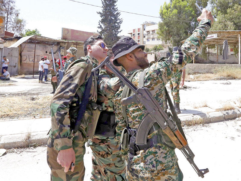 جنود الأسد يلتقطون الصور في حي القابون أمس (أ ف ب)