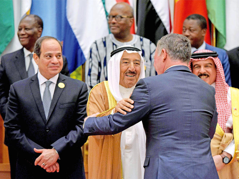 العاهل الأردني يلقي التحية على سمو أمير البلاد قبيل الصورة التذكارية للقمة     (أ ف ب)