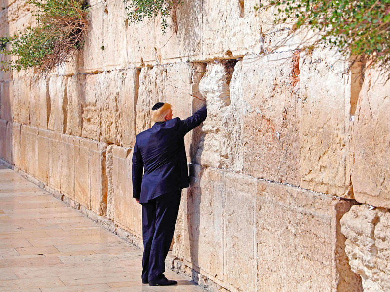 ترامب يدس ورقة في الحائط الغربي بالقدس أمس (أ ف ب)