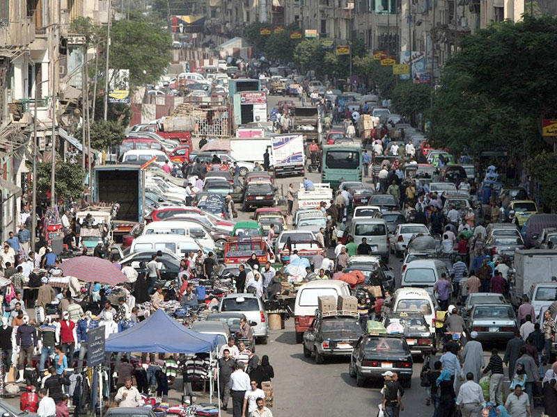 سوريون يتفقدون موقع انفجار السيارة المفخخة في حي الزهراء بحمص (أ ف ب)