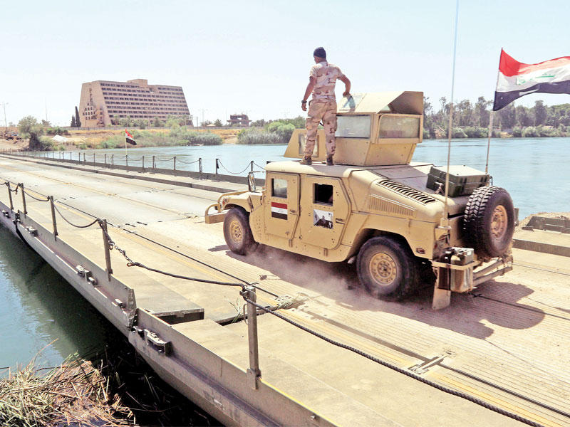 آلية تعبر أمس الجسر العائم الذي شيدته القوات العراقية في الموصلt(رويترز)