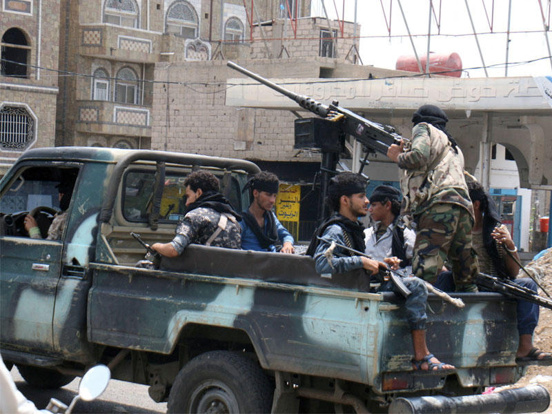 مقاتلون مؤيدون للحكومة يركبون شاحنة دورية في مدينة تعز