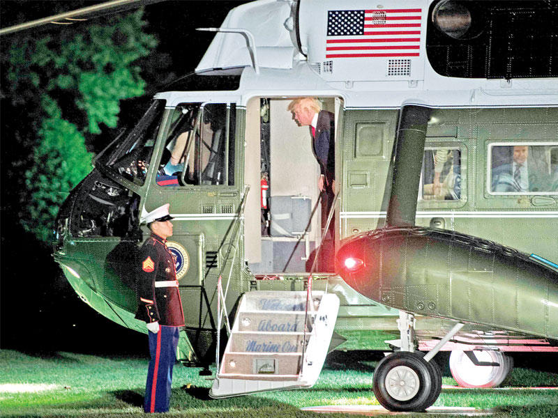 ترامب لدى نزوله من مروحيته الرئاسية في الحديقة الجنوبية للبيت الأبيض أمس الأول(أ ف ب)