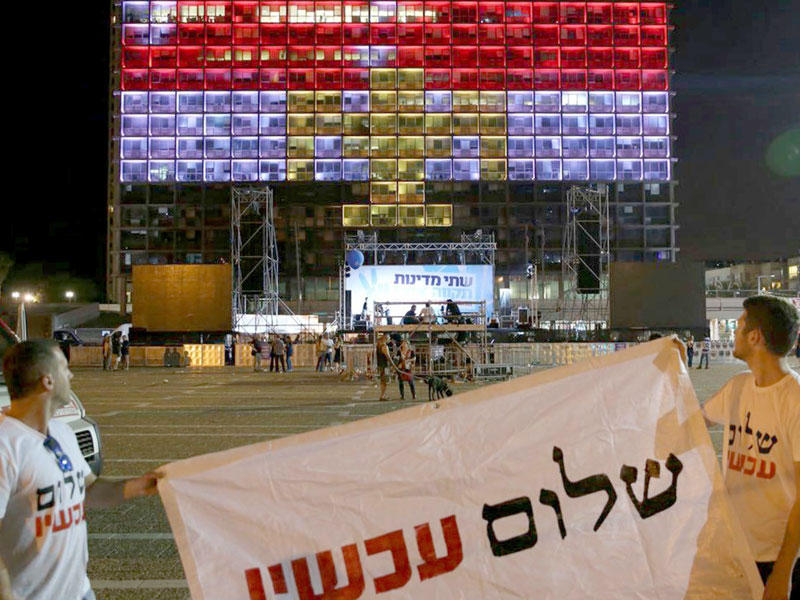 في لفتة تضامنية مع الأقباط عقب هجوم المنيا الدموي، زينت بلدية تل أبيب مبناها بألوان العلم المصري أمس الأول. وفي الصورة ناشط يساري يرفع لافتة كتب عليها «السلام» أمام المقر الإسرائيلي (أ ف ب)