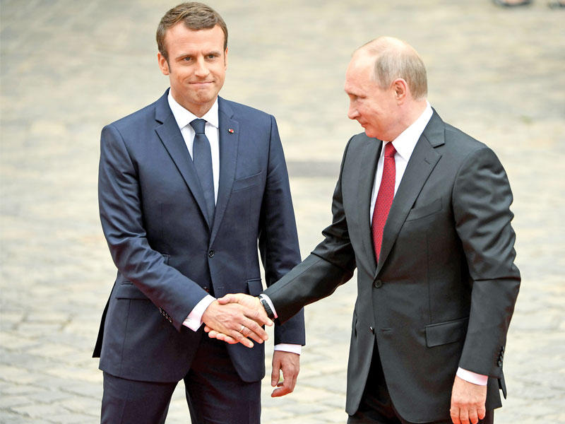 ماكرون مستقبلا بوتين في باحة قصر فرساي  اليوم (أ ف ب)