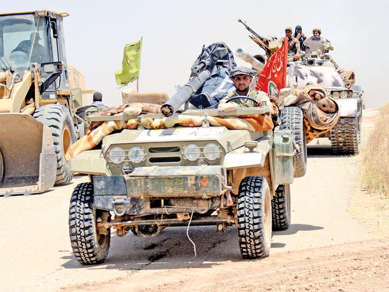 تمركز لآليات الحشد الشعبي في قرية أم جاريس على حدود سورية يوم الاثنين  (رويترز)