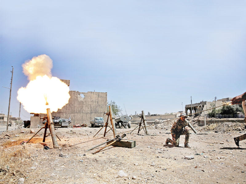 عنصر من القوات العراقية يحمل صاروخا خلال اشتباك مع عناصر داعش غرب الموصل أمس     (رويترز)