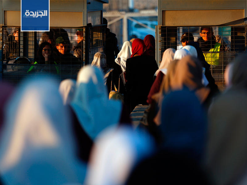 فلسطينيات يعبرون نقطة تفتيش اسرائيلية بين الضفة الغربية والقدس
