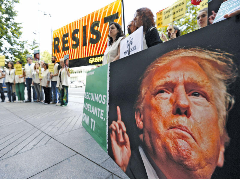 تظاهرة لـ «غرينبيس» مقابل السفارة الأميركية في مدريد أمس احتجاجاً على الانسحاب من اتفاقية باريس (اي بي أيه)