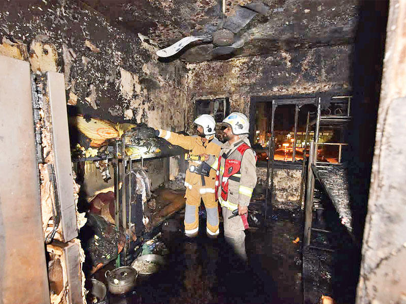 رجال الإطفاء يعاينون موقع الحريق