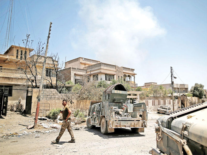 جندي عراقي ومركبات للجيش بعد سيطرته على منطقة في غرب الموصل أمس الأول  (رويترز)
