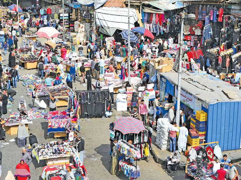 مصريون يتسوقون في سوق شعبي وسط القاهرة أمس الأول (رويترز)