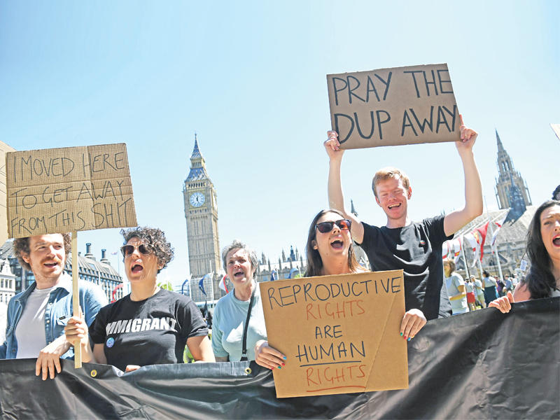 متظاهرون يحتجون في لندن  اليوم على التحالف بين ماي والحزب الوحدوي الديمقراطي المعروف بمحافظته الشديدة (أ ف ب)