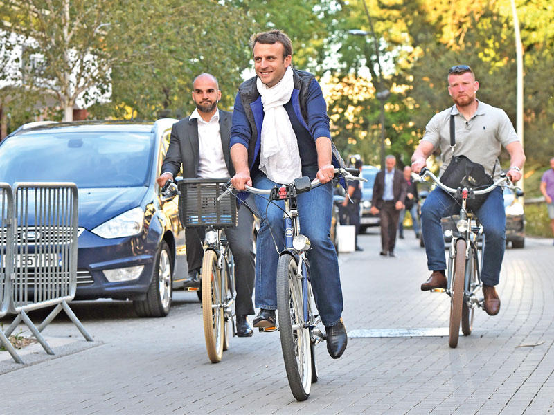 ماكرون يتجول بدراجته في لو توكيه شمال فرنسا عشية الانتخابات التشريعية (أ ف ب)