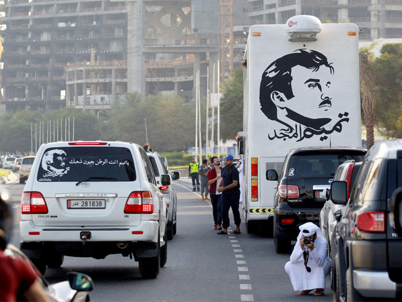 حافلة تحمل صورة أمير قطر خلال تجمع مؤيد له في الدوحة أمس الأول (رويترز)