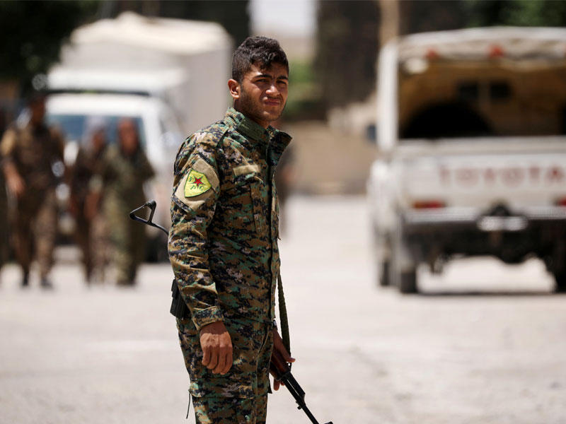 مقاتل من القوات الديمقراطية السورية يحمل سلاحه