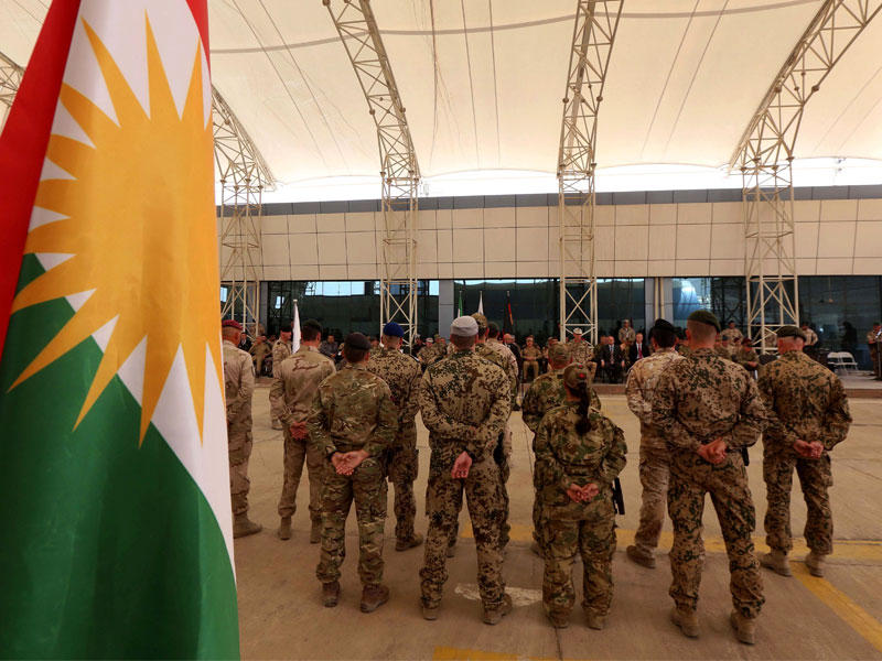 مستشارون عسكريون من قوات التحالف الدولي خلال مراسم نقل السلطة أمس، في مركز تنسيق التدريب الكردستاني في أربيلn(أ ف ب)