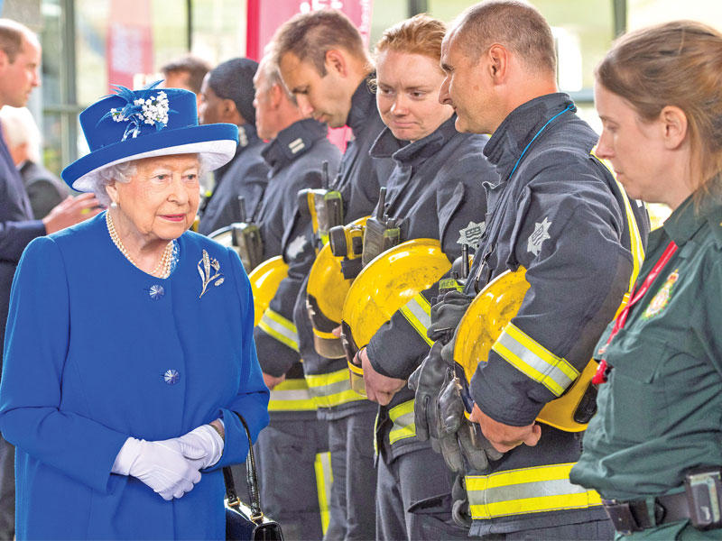الملكة إليزابيث تلتقي رجال إطفاء برج لندن أمس (رويترز)