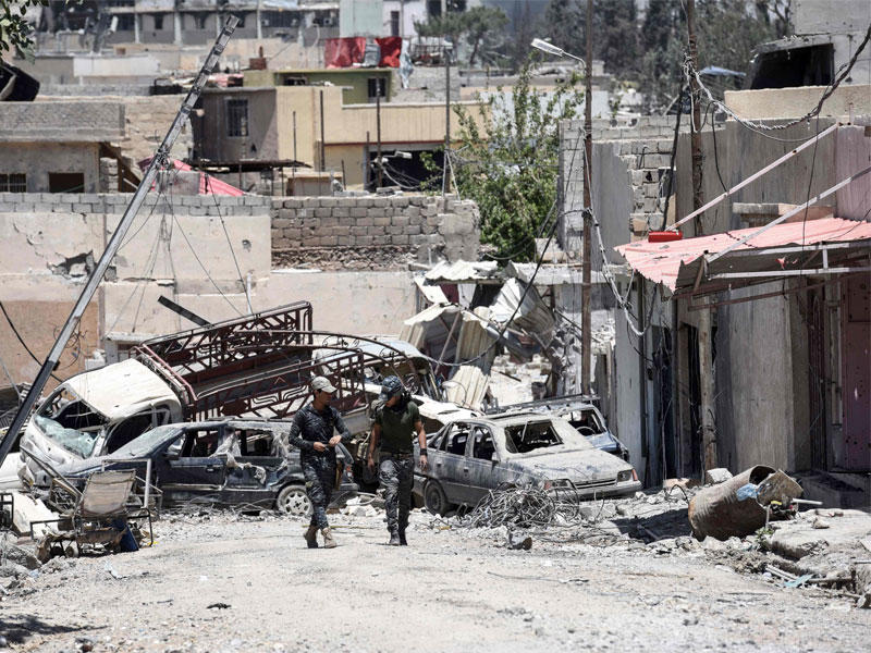 الجنود العراقيون يسيرون في شارع في منطقة الشفاء غرب الموصل