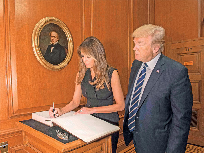 ترامب وزوجته ميلانيا أثناء توقيعهما في سجل زوار المحكمة العليا في واشنطن أمس الأولt(أ ف ب)
