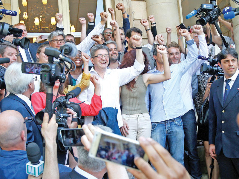 زعيم حركة «فرنسا المتمردة» اليسارية الراديكالية جان لوك ميلونشون ونواب الحركة الذي فازوا في الانتخابات يتجهون للمشاركة  في اول اجتماع للبرلمان أمس في باريس (رويترز)