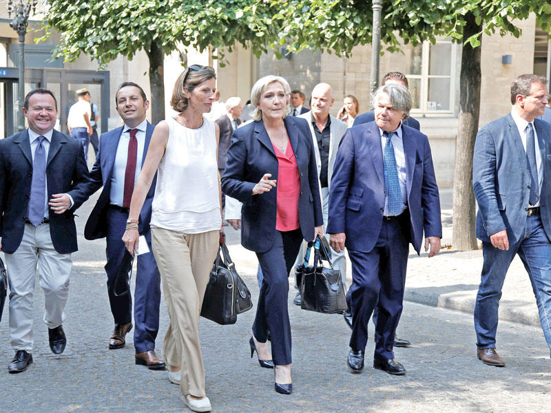 زعيمة اليمين المتطرف مارين لوبان ونواب حزب الجبهة الوطنية الجدد يصلون إلى البرلمان في باريس أمس (رويترز)