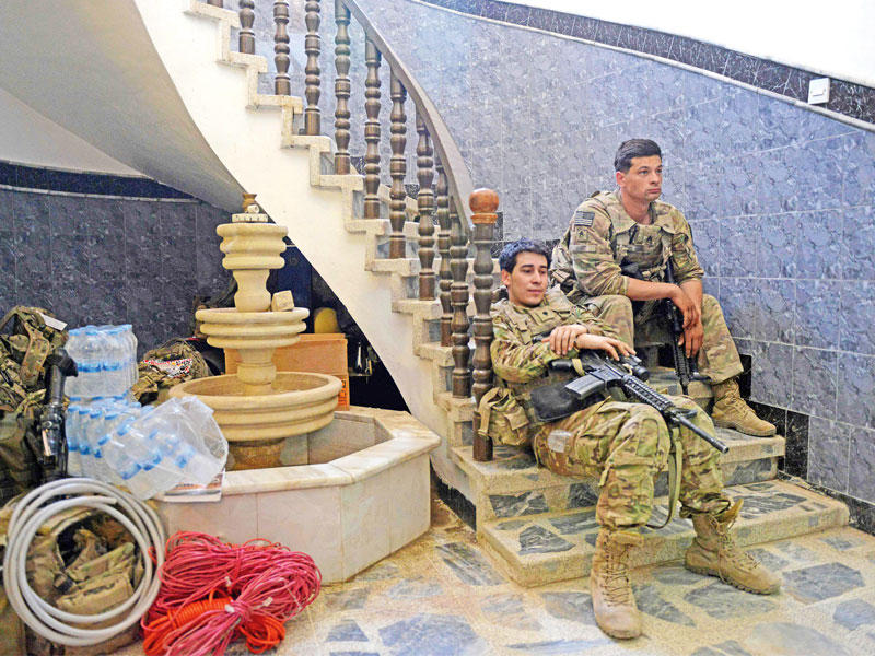 جنديان أميركيان يرتاحان  بعد معارك داخل الموصل أمس (أ ف ب)