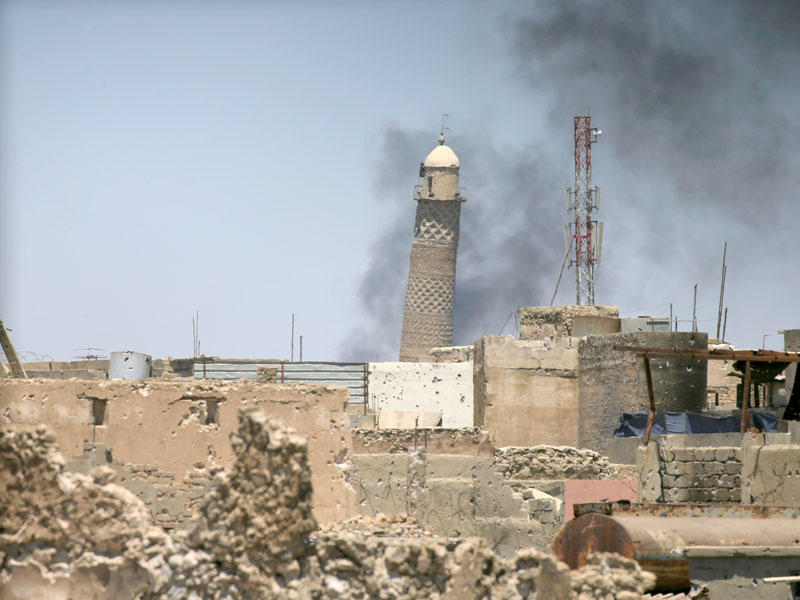 الدخان يتصاعد من خلف المنارة الحدباء لمسجد النوري  (رويترز)
