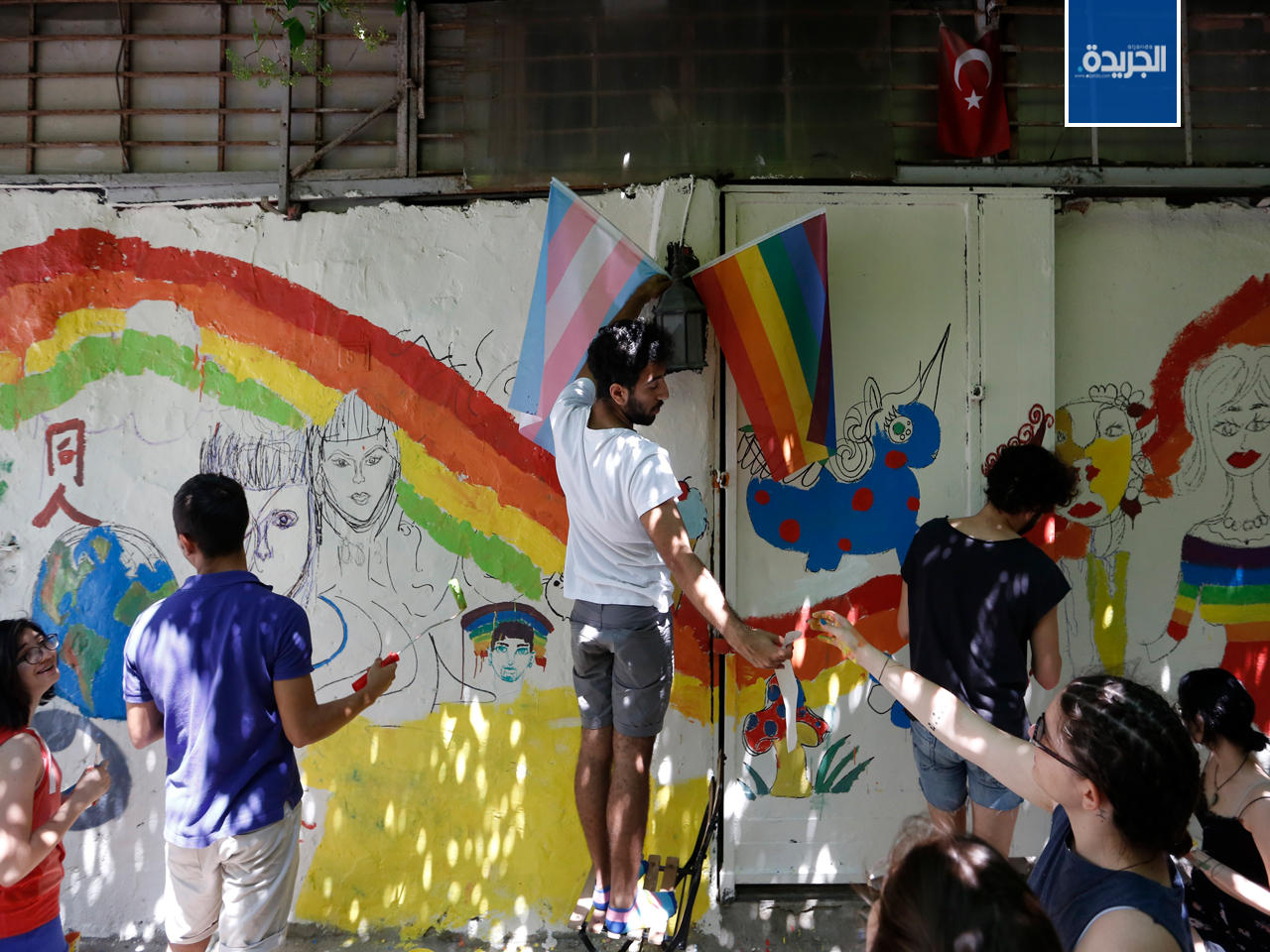 منظمو المسيرة يصبغون جدار بألوان وشعارات ترمز للمثلية