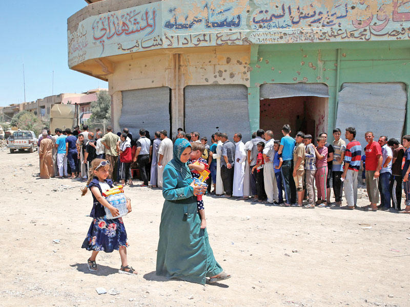 عراقية حصلت مع ولديها حصتهم من المساعدات الغذائية غرب الموصل أمس الأول