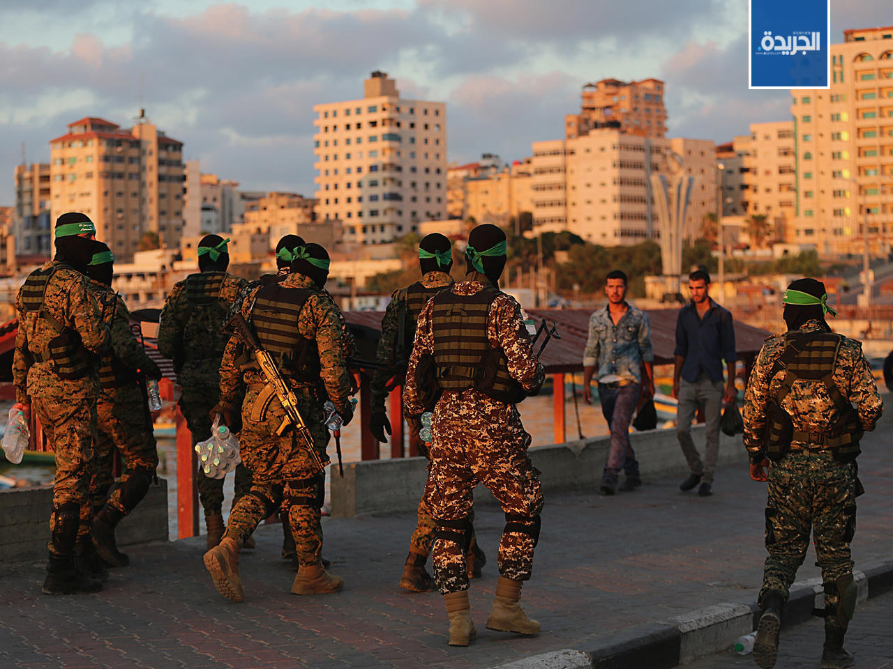 عناصر من كتائب عز الدين القسام الجناح لحركة حماس الفلسطينية يوزعون الطعام والمياه في مدينة غزة