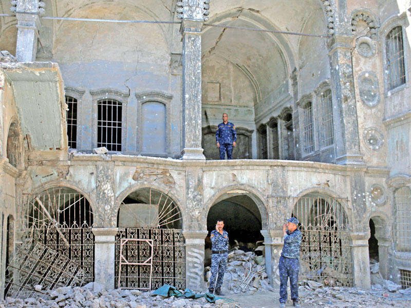 عناصر من الشرطة الاتحادية العراقية أمام كنيسة سمعان الصفا التاريخية في الموصل القديمة أمس           (رويترز)