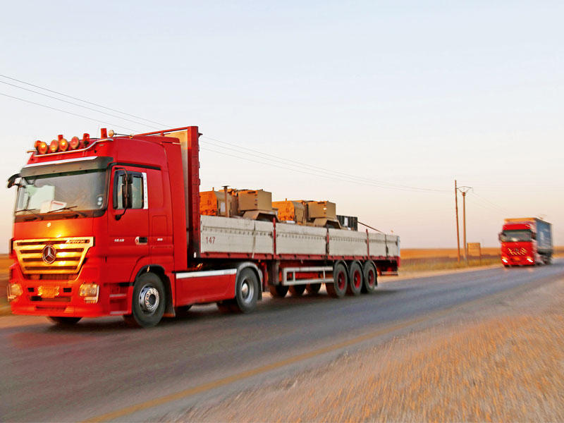 قافلة شاحنات تحمل مدرعات وذخائر أميركية على طريق عين عيسى شمال الرقة أمس الأول (أ ف ب)