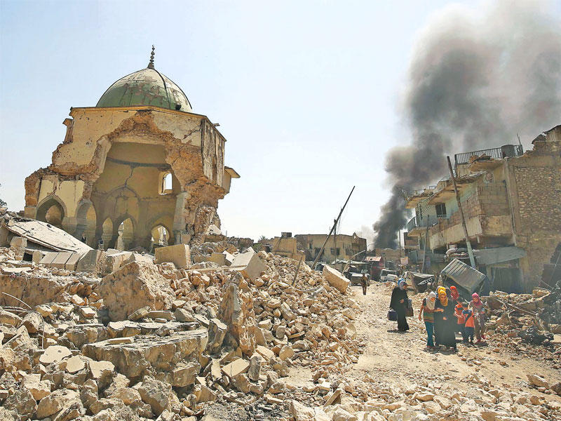 عراقيون يفرون من المعارك في محيط ما تبقى من مسجد النوري المهدم وسط الموصل أمس (أ ف ب)