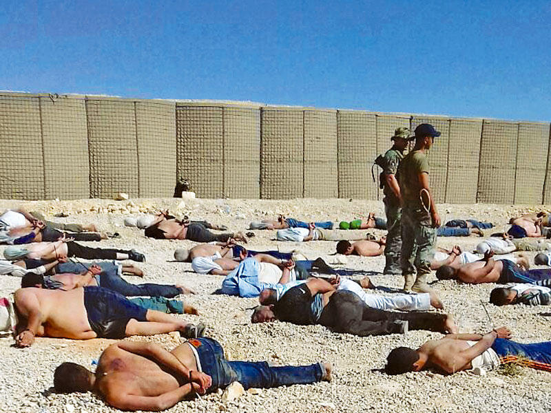 جنديان لبنانيان إلى جانب عشرات المعتقلين في عرسال أمس
