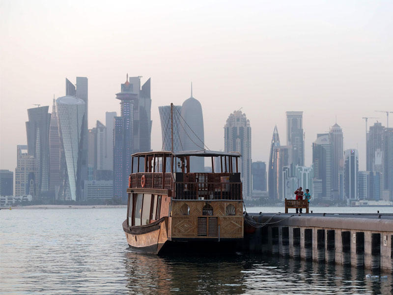 الأطفال يأخذون صورة لقارب على الكورنيش في العاصمة القطرية الدوحة